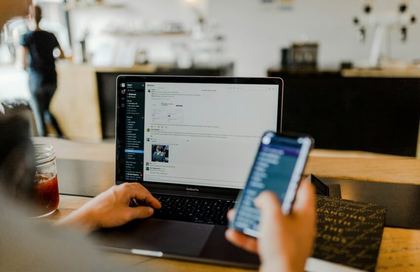 Marketer reviewing social media ads on phone and laptop